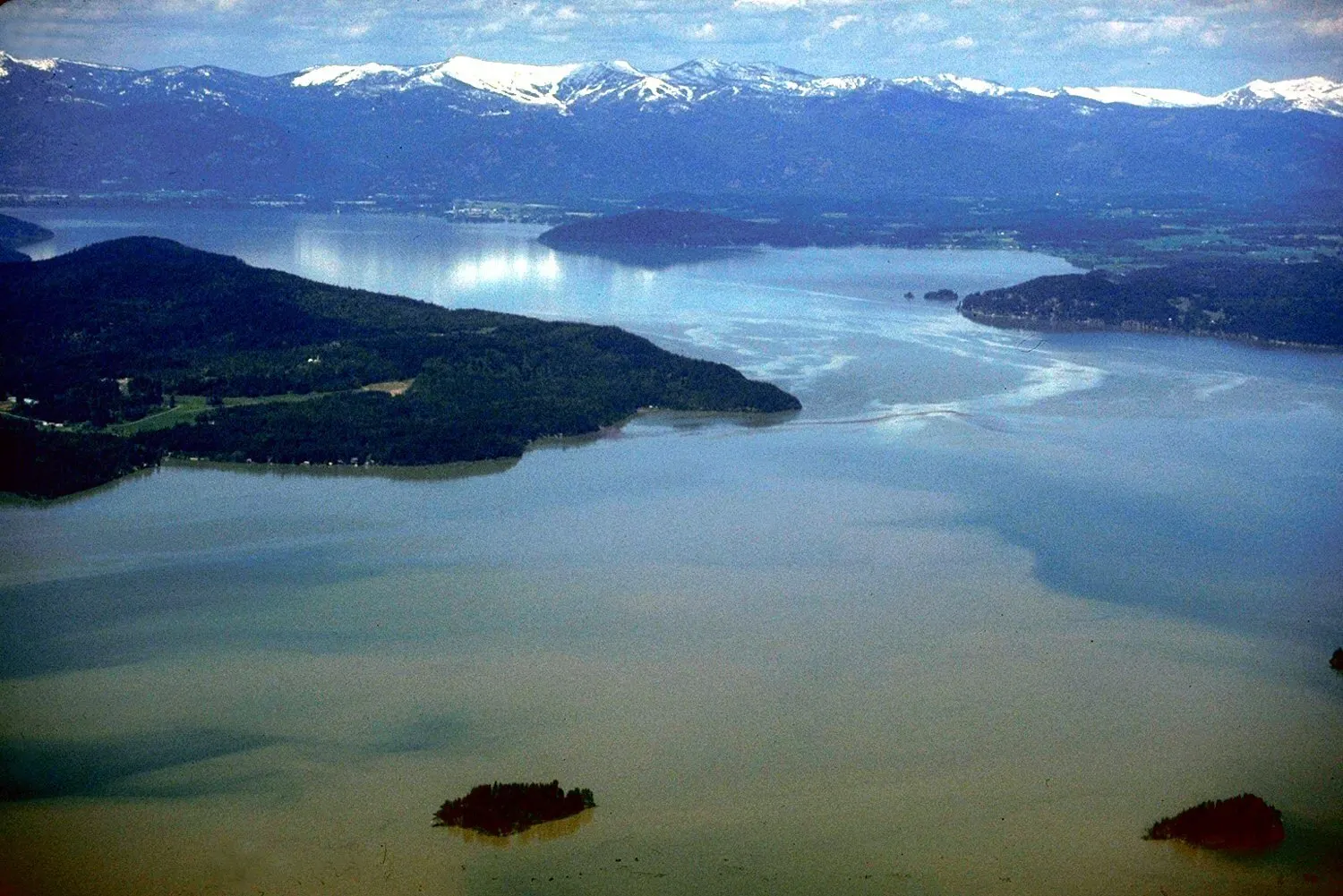 Lake Pend Oreille, open water below timbered shoreline.
